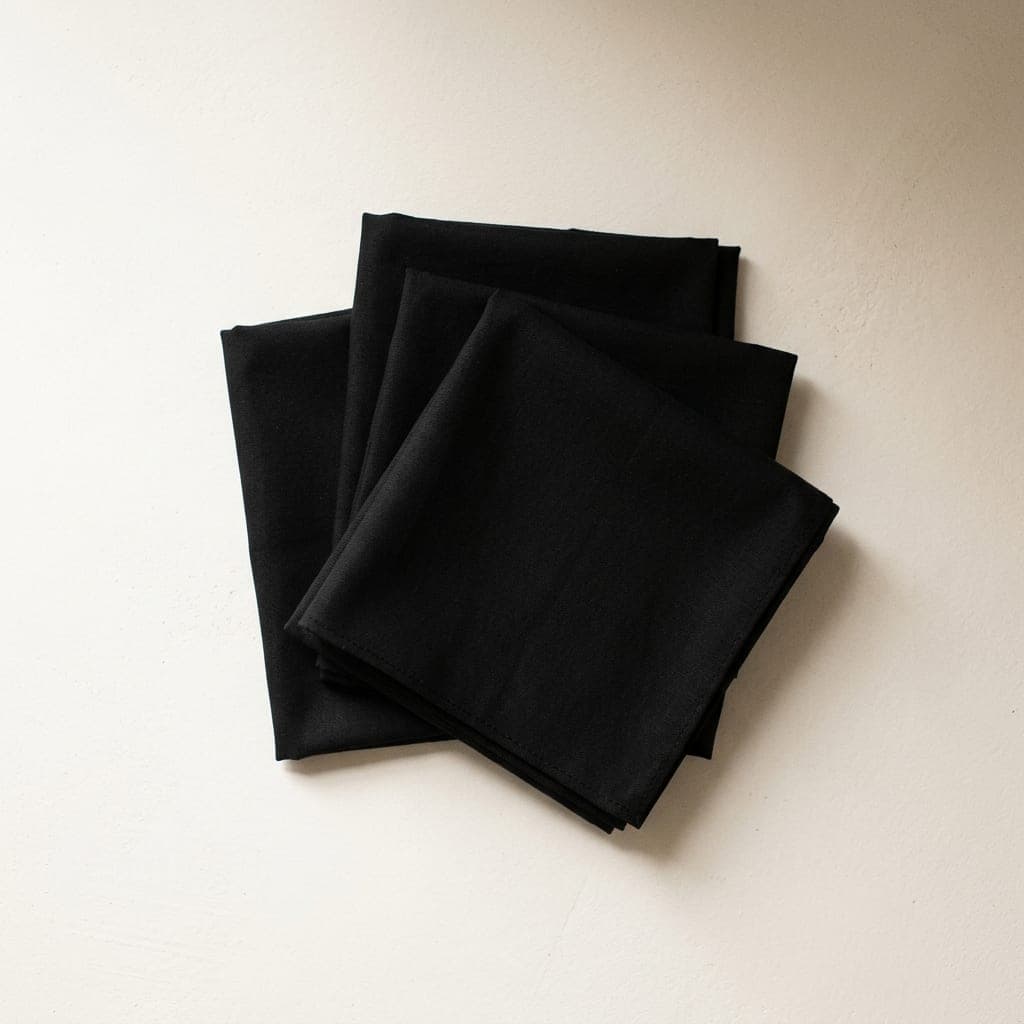 Folded squares of cotton poplin in true black