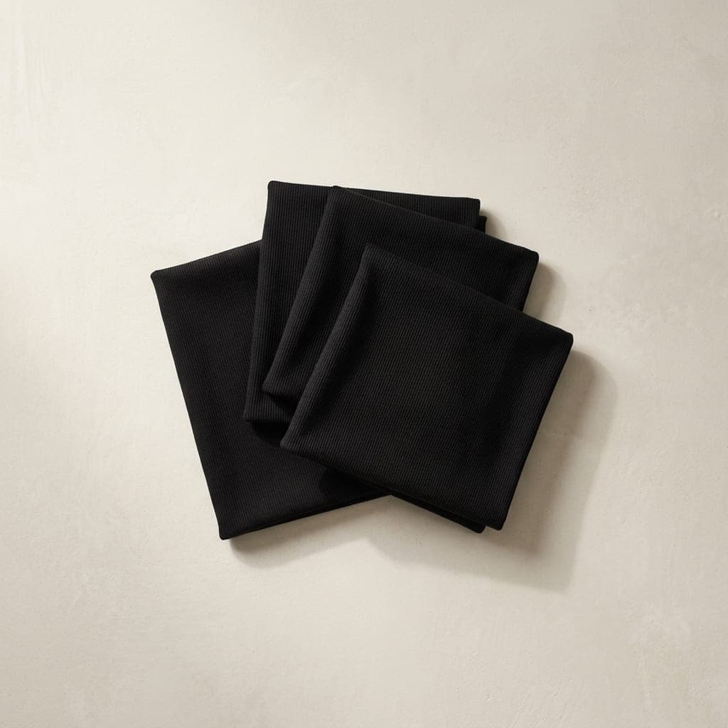Folded squares of ribbed knit in true black