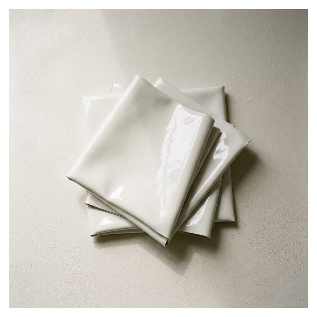 Folded squares of patent leather in clean white