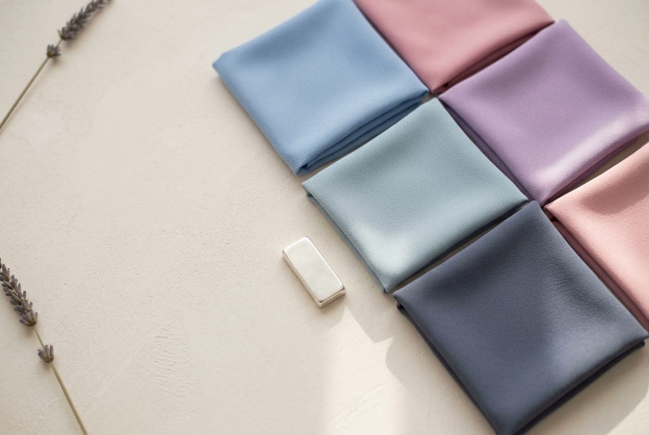 Folded squares of fabric in the Light Summer palette, with its best neutral and metal