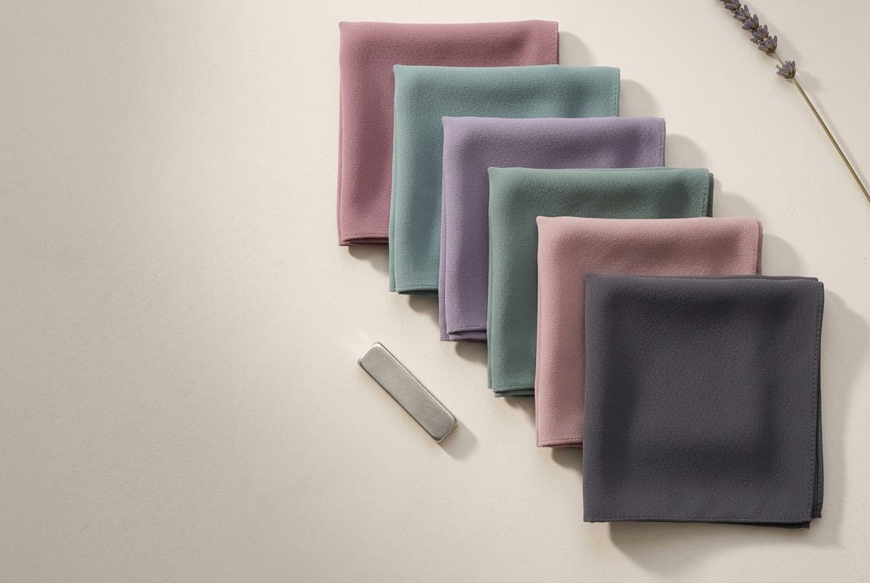 Folded squares of fabric in the Soft Summer palette, with its best neutral and metal